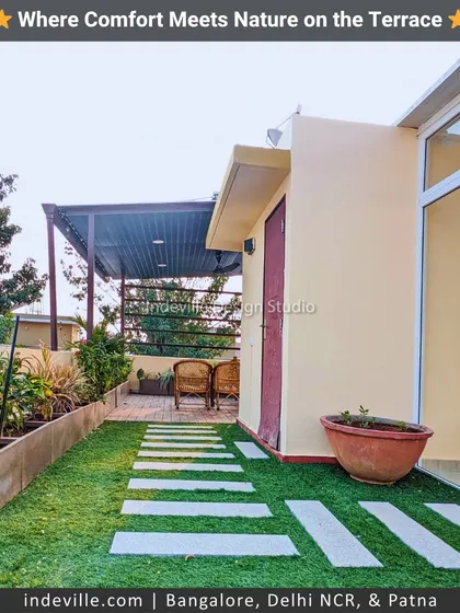 This is a functional walkway I designed along the side of a terrace. It features stone pavers on artificial grass, leading to a seating area, and is lined with trough planters to maximize greenery in a narrow space.