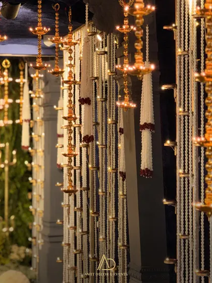A duplicate of image 1, showing the beautiful hanging diyas and floral strings that create a devotional atmosphere.