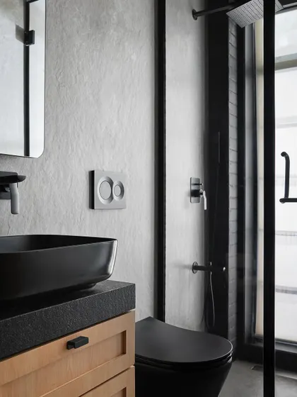 In the Zen House master bathroom, we used a light grey concrete finish on the walls for a soft, minimalist feel. Black fixtures and a black vessel sink provide a strong, grounding contrast.