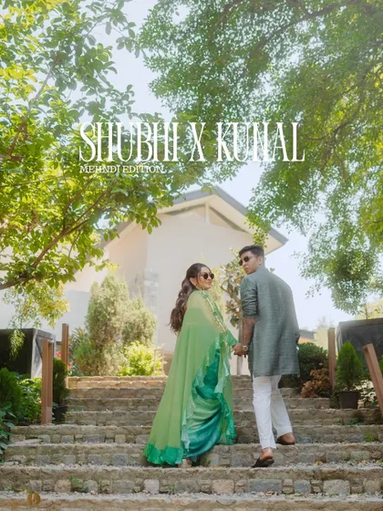 A stylish shot of a couple walking up a stone staircase at their destination mehndi in Jim Corbett. Their coordinated green outfits and the lush scenery create a beautiful, magazine-worthy photo.