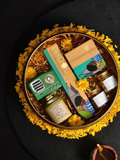 A vibrant and quirky gift platter featuring a retro-style speaker and products from Phool. This is for clients who want something unique and full of personality.