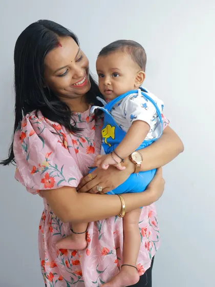 A mother's gentle hold. This portrait beautifully captures the love and adoration a mom has for her baby, a simple yet profound moment frozen in time.