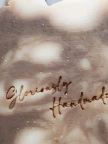 A detailed close-up of the "Gloriously Handmade" stamp on my Neem Cucumber soap. This is my personal seal of quality and care on every bar I make.