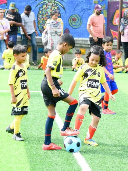 A young player learns ball control under the watchful eyes of parents at our weekend session. My academy encourages family involvement and creates a supportive community atmosphere.