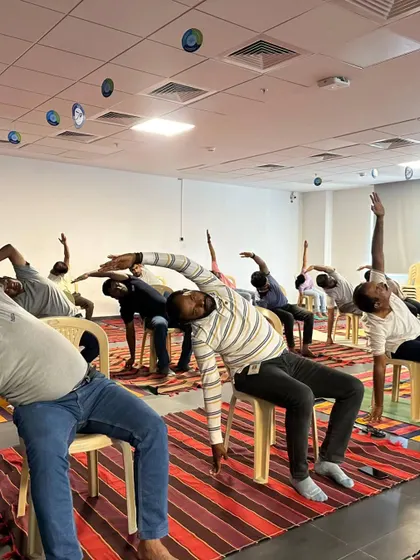 Another view of the seated side stretch at Autoliv. Chair yoga makes wellness accessible to everyone in the office, allowing for a refreshing break without disrupting the workflow too much.