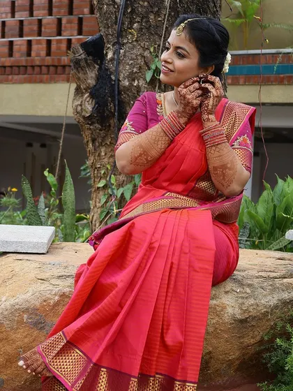 A candid shot of the bride sitting outdoors, the natural light highlighting the beautiful color of her mehendi stain.