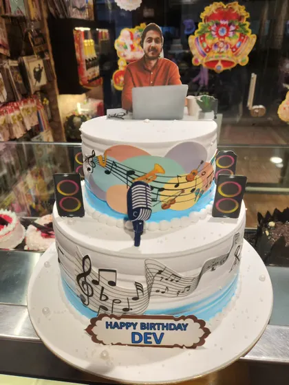 A three-tier cake that hits all the right notes for a music lover's birthday. Decorated with musical notes, instruments, and a personalized photo topper, this cake celebrates a passion for music.
