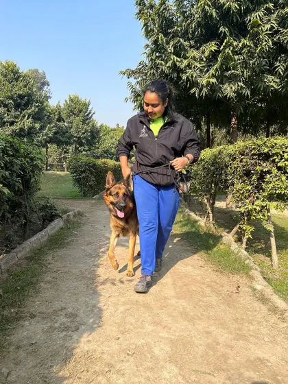 Proving that women can absolutely train big, strong dogs. Here I am with Phantom, a German Shepherd, practicing a focused heel during an outdoor session. A calm, structured walk is foundational for a well-behaved dog.