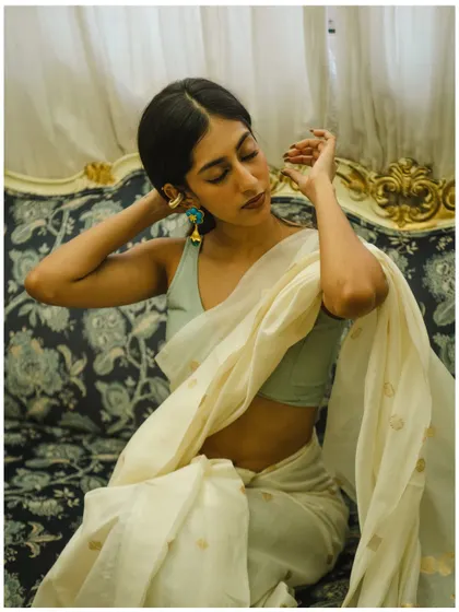 An intimate and delicate pose, focusing on the details of the jewelry and the soft expression of the model.