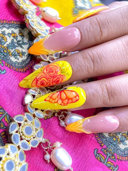This vibrant yellow nail art for Navratri features intricate, hand-painted roses and a butterfly, combined with 3D sculpted flame-like tips.