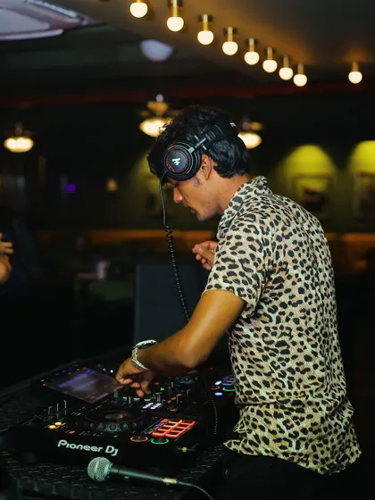 In the zone, mixing tracks and feeling the energy of the room. This is me during a live DJ set, focused on crafting the perfect sound for the night on my Pioneer DJ console.