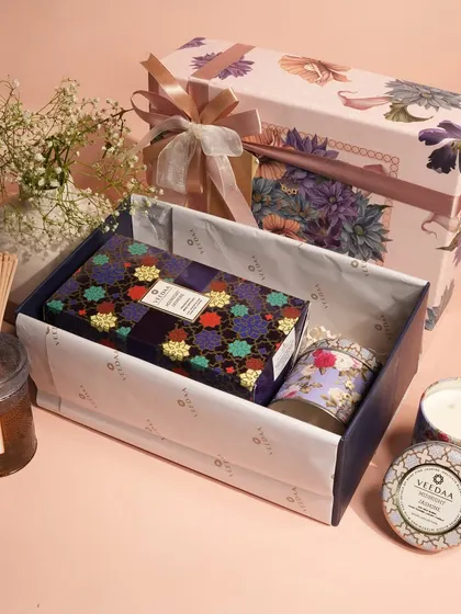 A soft, floral-themed gift set being assembled with care. This collection, featuring a reed diffuser and our popular tin candles, is a wonderful way to share the gift of a beautifully scented home.