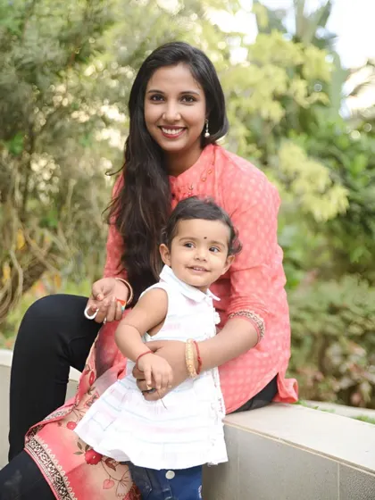 A lovely mother-daughter portrait taken outdoors. The soft natural light and their warm smiles make this a beautiful memory.