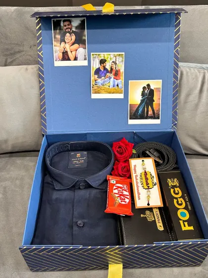 A sophisticated Rakhi gift hamper for a brother. This set includes a formal shirt, a personalized wallet and Fogg perfume, a rakhi, and chocolates, with custom photos displayed inside the lid of the box.