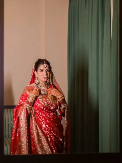 A candid moment of the bride looking at her reflection. It's a quiet, personal moment of anticipation on her wedding day.