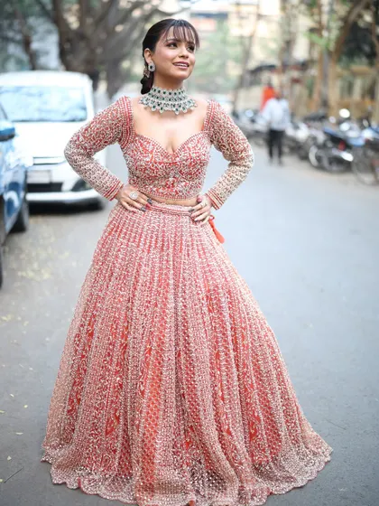 A full-length shot of the peach lehenga, showing off its beautiful color and sparkling details.