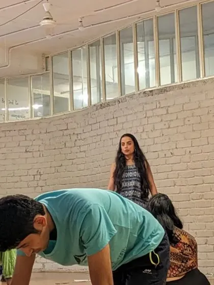 An instructor observes and guides as participants engage in a floor-based movement exercise. We provide gentle support throughout the process.