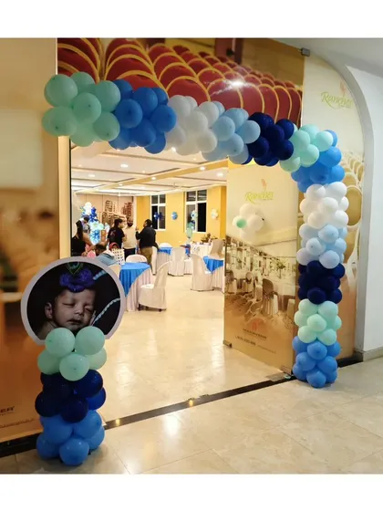 A fun and festive balloon archway to welcome guests to a Little Krishna themed party. A custom photo stand of the baby adds a wonderful personal touch right at the entrance.