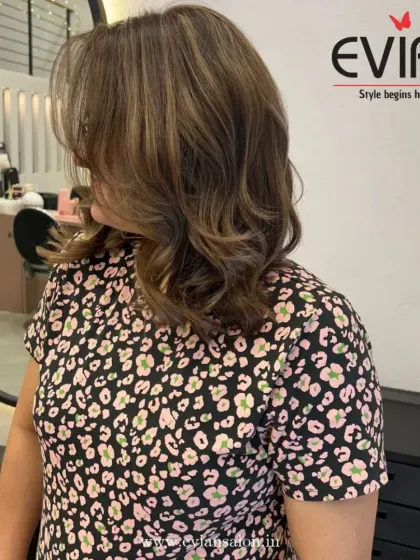 A side profile of a beautiful highlight job on a shoulder-length bob. The color adds dimension without being overwhelming, perfect for a professional and chic style.