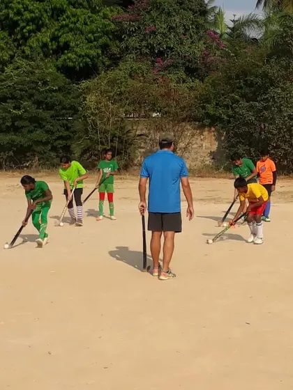 A coach provides one-on-one instruction to a group of young players. This personalized attention ensures that every camper understands the fundamentals and corrects their technique.