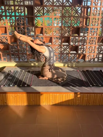 A supported backbend in a restorative practice. This gentle opening of the heart, with the sun shining through the window, is a beautiful way to slow down.