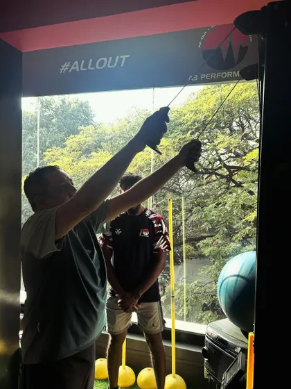 A client performs a single-arm cable pulldown, focusing on building back strength and stability.