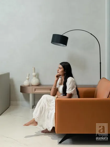 An elegant tan leather sofa designed for a minimalist aesthetic. Paired with a modern arc lamp, it creates a sophisticated corner for reading and contemplation.
