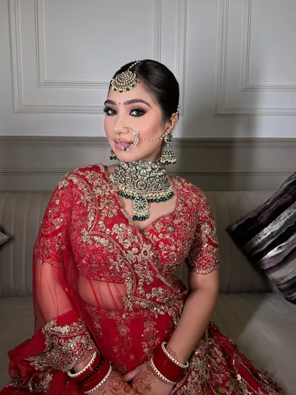 This bride is radiating pure bliss in her red lehenga and our heavy polki choker set with green accents. A perfect example of a modern yet minimal bridal look.