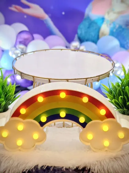 A light-up rainbow prop, adding a touch of color and magic to a 'Frozen' themed party.