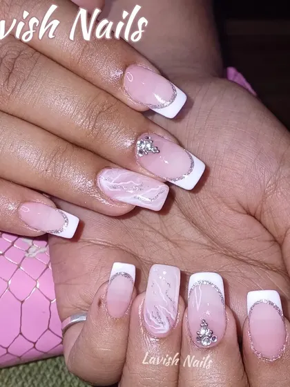 This set combines a classic French manicure with modern accents, including a white marble effect nail and strategically placed crystal clusters for a touch of sparkle.