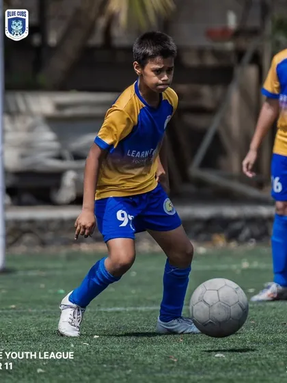 A U11 player looking up to make a pass, demonstrating good game awareness.