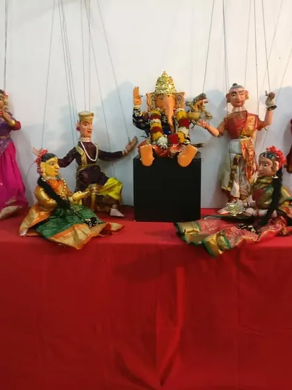 A display featuring Lord Ganesha at the center, surrounded by musicians and other characters. This arrangement shows how puppets are used to create entire scenes from mythology and folklore.