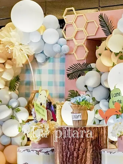 A detailed shot of the Pooh-themed decor, showing the intricate layering of balloons, props, and textures to create a rich visual experience.