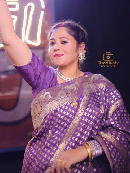 A beautiful portrait of a wedding guest in a traditional purple saree, enjoying the celebrations. We ensure every important person feels seen.