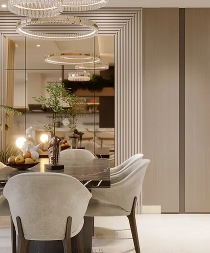 A detailed shot of the dining area in our beige and wood-themed living space. The design uses a large mirror to create a sense of depth, reflecting the modern chandelier and clean lines of the room.
