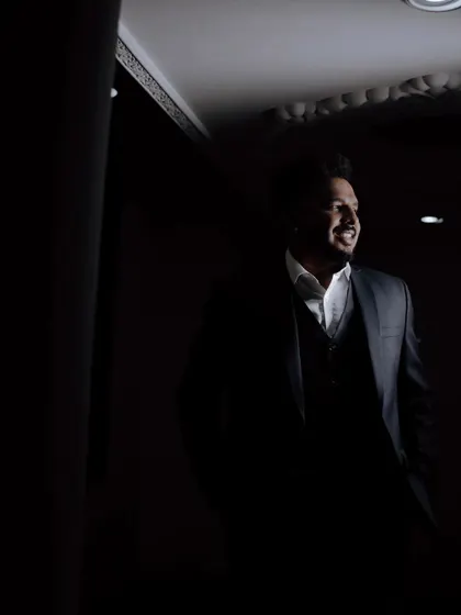 A stylish, low-light portrait of the groom looking dapper in his reception suit.