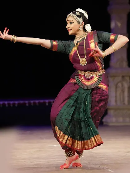 A graceful pose from "Shivaantarangam," showcasing the fluidity of movement within the Thanjavur style. The costume, in shades of green and purple, was chosen for this specific production.