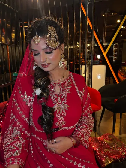 This candid-style shot shows the bride adjusting her hair, giving a glimpse of the detailed hairstyle and the delicate nose ring. It’s these small details that complete the traditional bridal ensemble.
