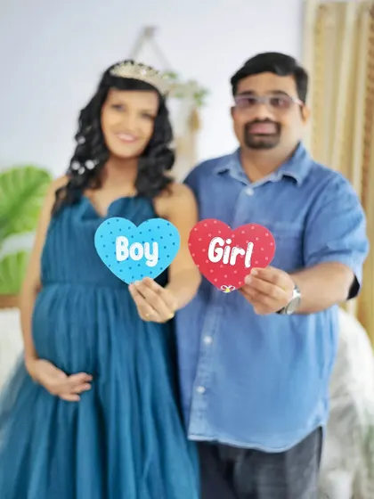 Boy or Girl? This couple holds up heart-shaped signs, keeping the surprise alive in this fun and colorful gender reveal photo.