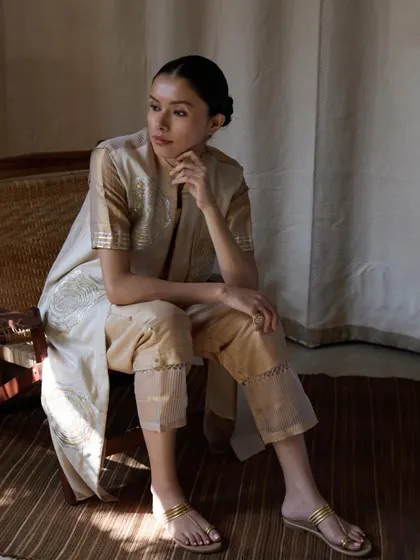 A lifestyle shot for the same collection, using natural window light. This creates a soft, contemplative mood and shows how the outfit can be worn in a real-life setting.