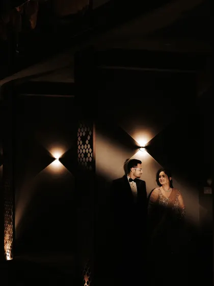 A quiet moment shared between the couple, framed by dramatic lighting. This intimate, low-light portrait captures their connection away from the dance floor.