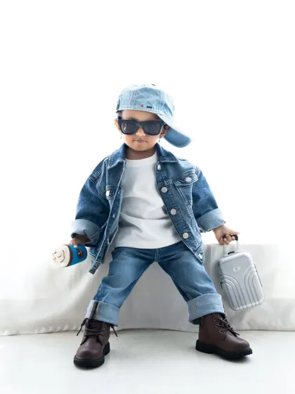 A confident stance from this stylish toddler. The simple white background makes his cool outfit pop.