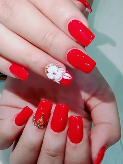 A glamorous red set for a special occasion, with 3D floral designs and intricate rhinestone placements.