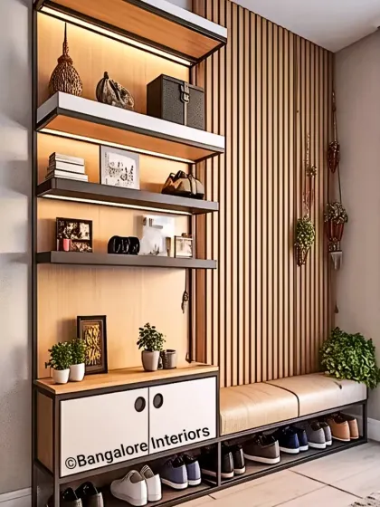 A modern entryway design featuring a mix of materials. This unit combines a cushioned bench with open shoe storage, a vertical shelving unit with backlighting, and a closed lower cabinet, all set against a wood-paneled wall.