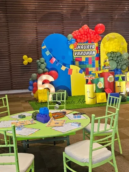 Themed seating for the little builders, with bright green tables and chairs set against the backdrop of the main LEGO stage.