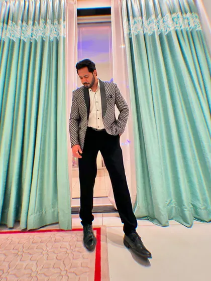 A stylish pose in a modern, patterned tuxedo jacket, showcasing a contemporary look for evening events.