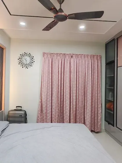 This stylish wardrobe uses a geometric pattern of pastel pink and grey laminates, outlined with sleek black profiles. The design includes a section with fluted glass for a partially see-through effect, adding a touch of modern flair.