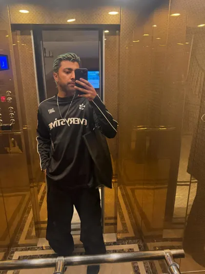 An elevator selfie showing off a long-sleeve jersey look.