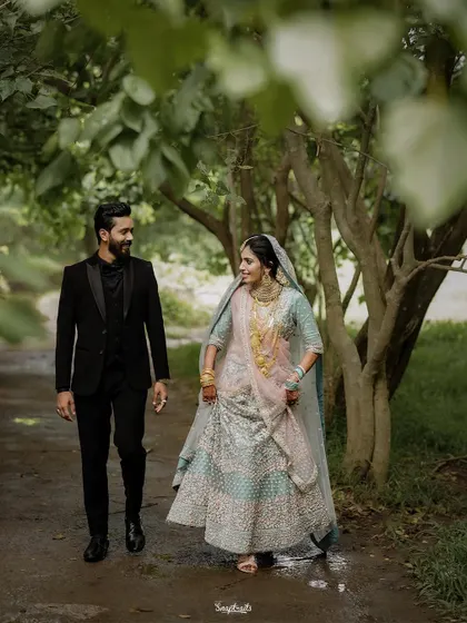 A walk to remember. This shot captures the couple in a serene, natural setting, their elegant outfits contrasting beautifully with the rustic path. It’s a perfect example of a cinematic wedding moment.