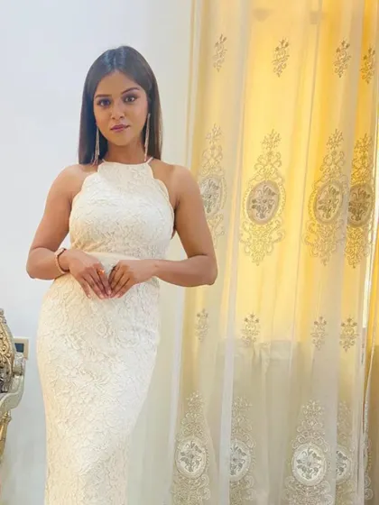 A client posing in the white lace gown, which fits beautifully and creates a sleek silhouette.